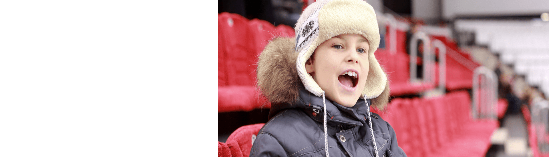 Boy Cheering on bleachers in arena